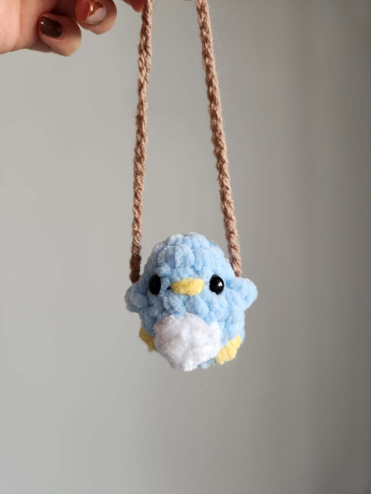 Peluche petit oiseau sur une balançoire