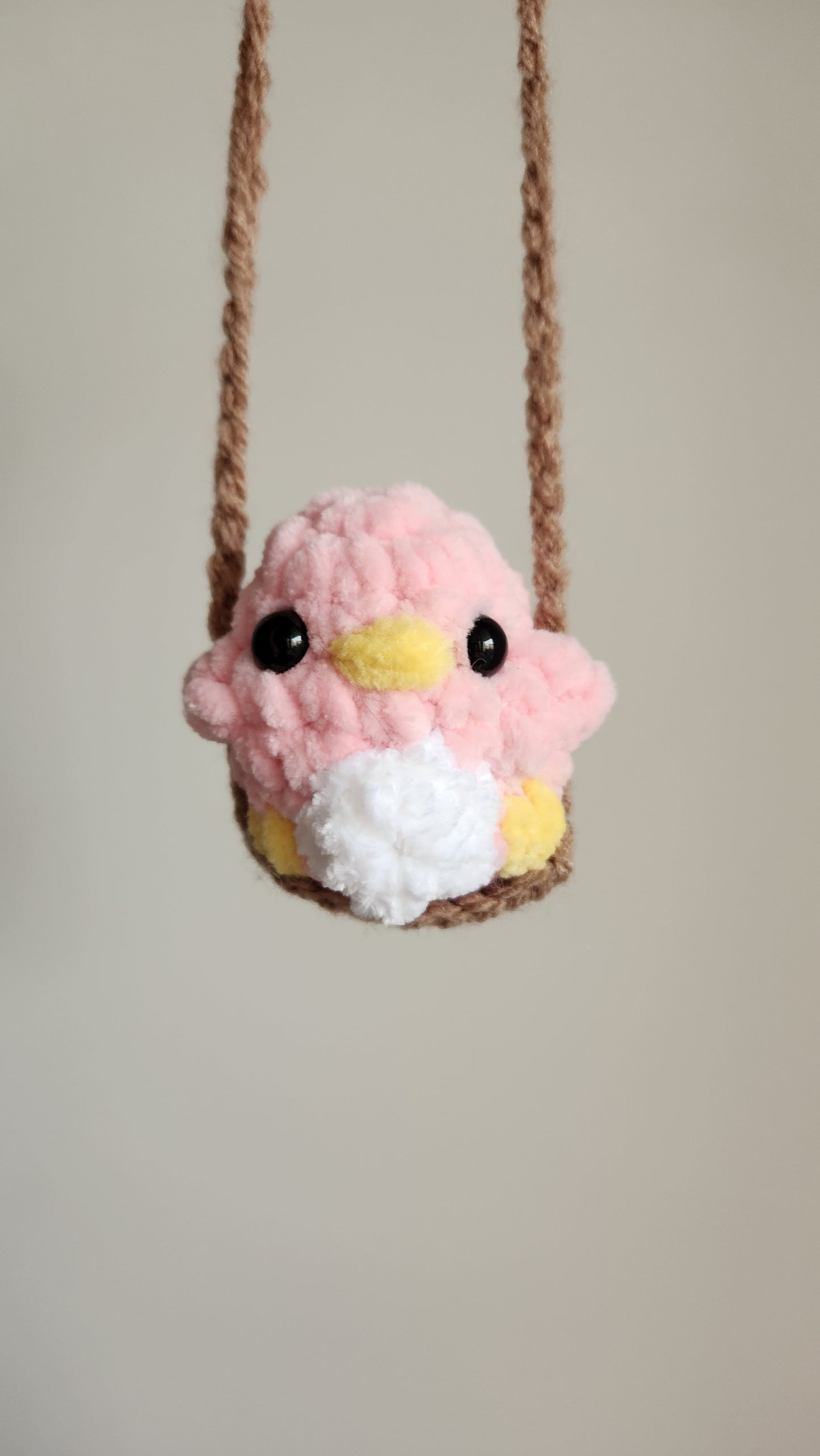 Peluche petit oiseau sur une balançoire